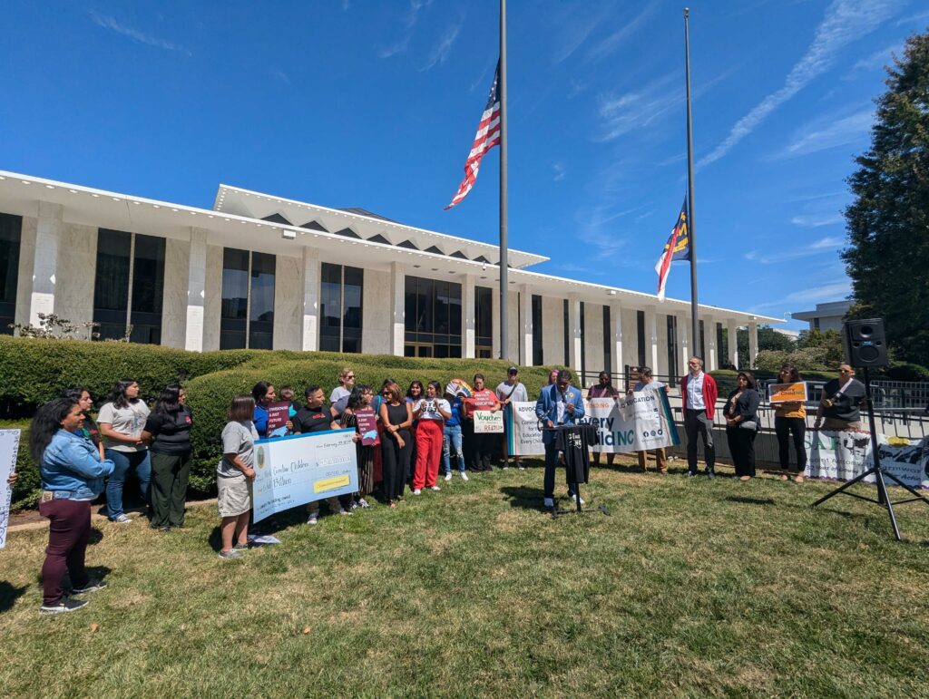 Education justice advocates standing outside North Carolina General Assembly holding press conference against the legislature's decision to approve school voucher expansion